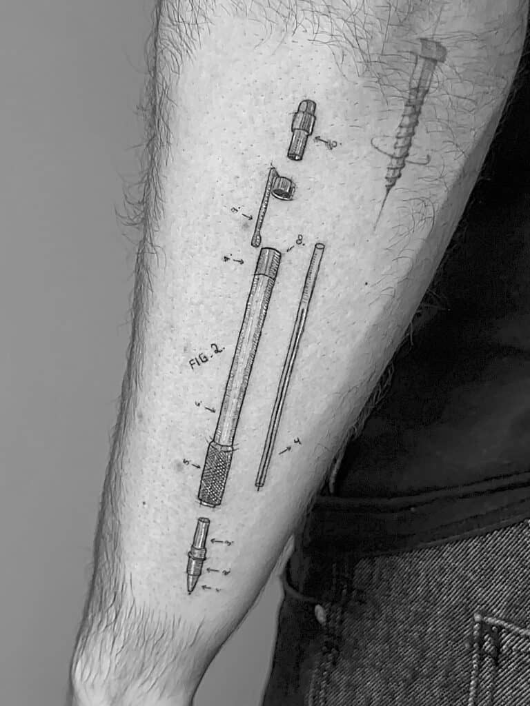 Tatuaje de partes de un bolígrafo en el antebrazo