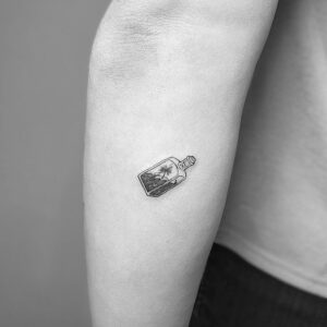 Tatuaje línea fina de botella vídrio en brazo