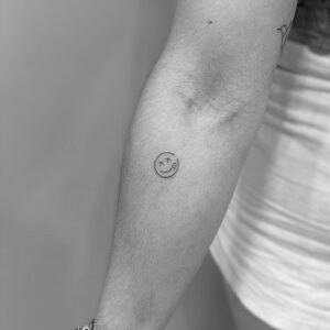 Tatuaje micro de smile en brazo