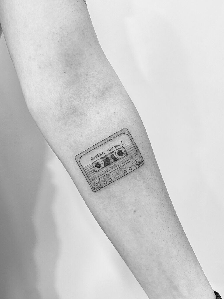 Tatuaje de línea fina de cinta de cassette en el antebrazo