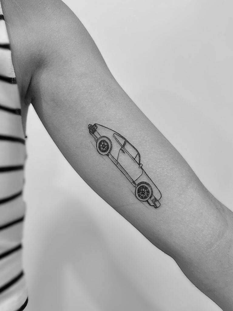 Tatuaje de línea fina de coche en el brazo