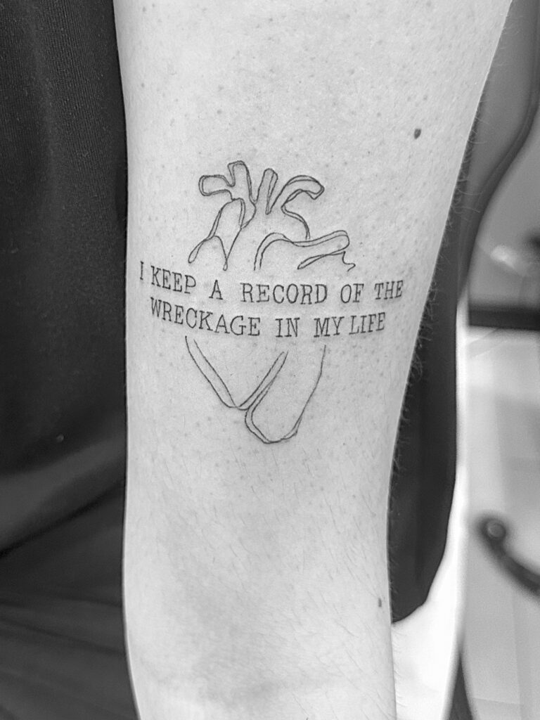 Tatuaje de línea fina de silueta de corazón anatómico con frase