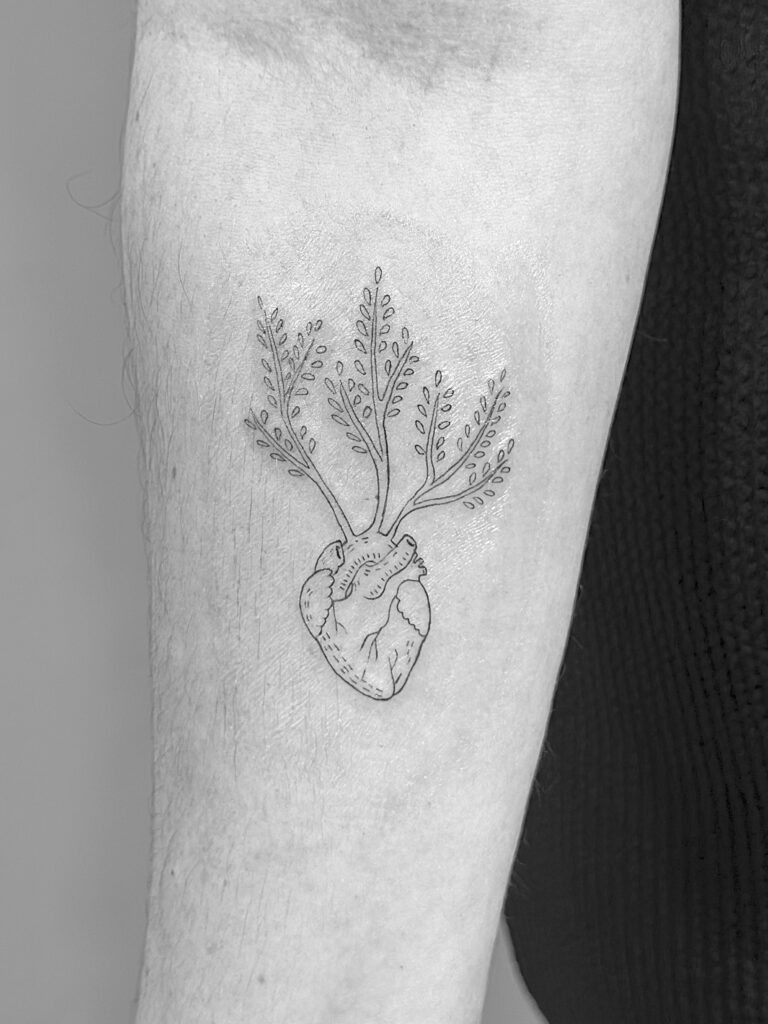 Tatuaje de línea fina de silueta de corazón anatómico con ramas en el brazo