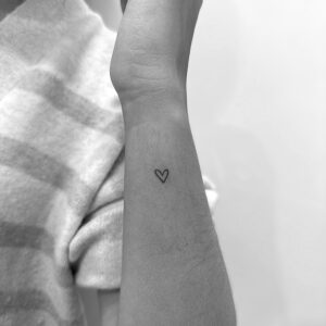 Tatuaje de micro corazón en la muñeca