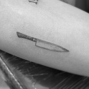 Tatuaje de cuchillo de línea fina en brazo
