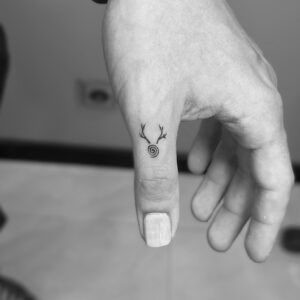 Micro tatuaje simbólico ciervo en dedo