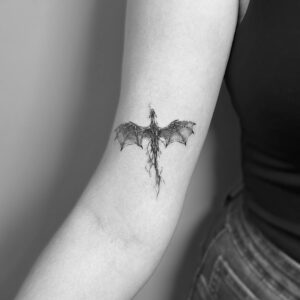 Tatuaje línea fina de dragón en el brazo