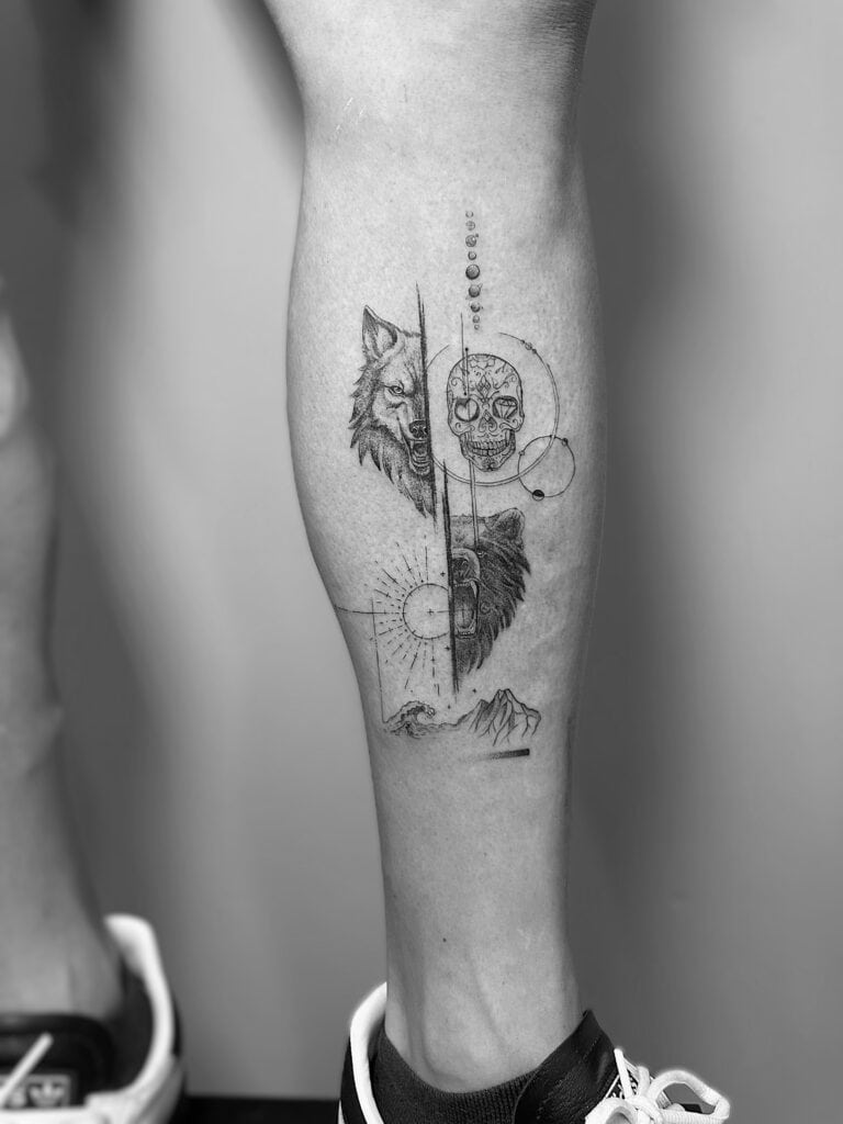 Tatuaje geométrico compuesto con lobo oso y paisaje en la pierna