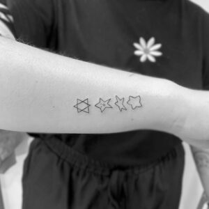 Tatuaje línea fina de estrellas en antebrazo