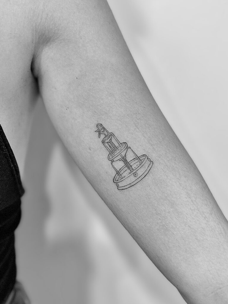 Tatuaje de línea fina de fuente en el brazo