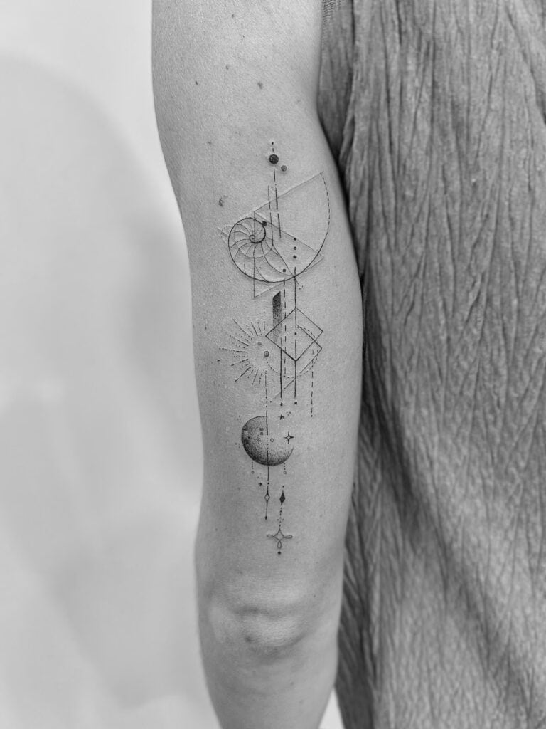 Tatuaje de línea fina en brazo de distintos elementos geométricos