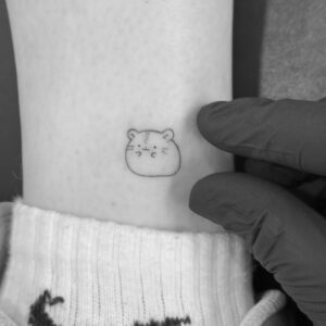Tatuaje línea fina de mini hamster en el tobillo