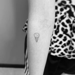 Tatuaje línea fina de mini helado en el antebrazo