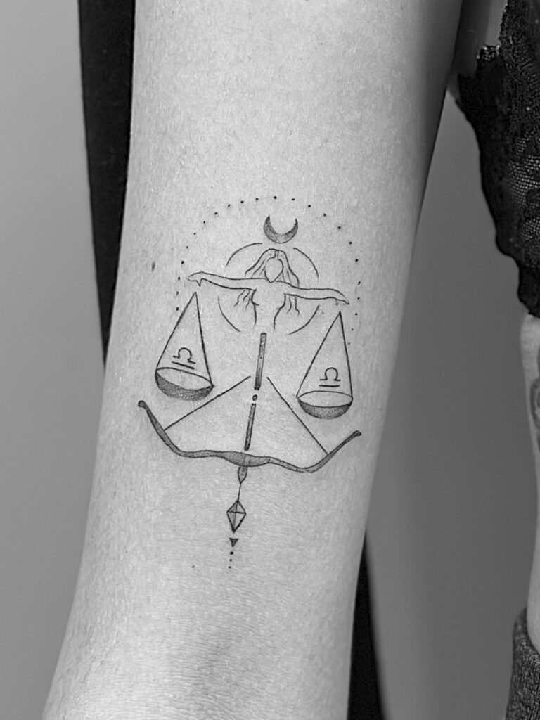 Tatuaje de línea fina de símbolos de la justicia en el brazo