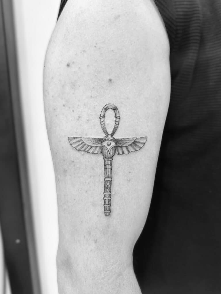 Tatuaje de línea fina de llave egipcia en el brazo