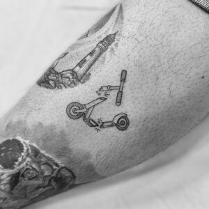 Tatuaje pequeño de patinete en la pierna
