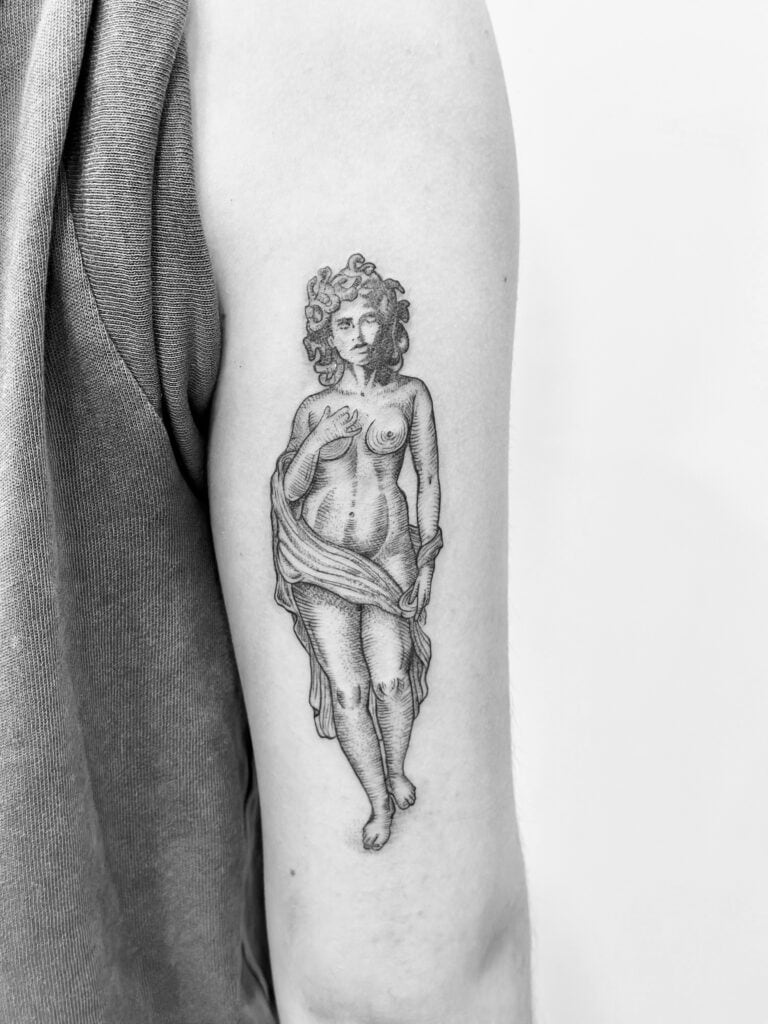 Tatuaje de mujer de inspiración clásica en el brazo