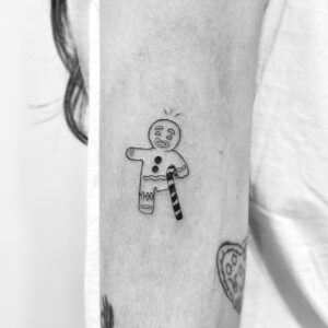 Tatuaje pequeño de muñeco de jengibre en el brazo
