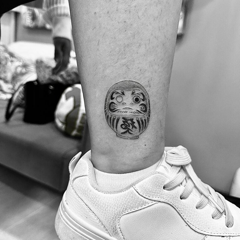 Tatuaje de muñeco cultura japonesa en el tobillo