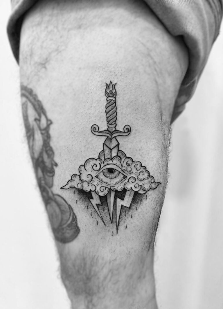 Tatuaje de nube con espada en el muslo