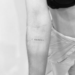 Mini tatuaje de palabra en el antebrazo