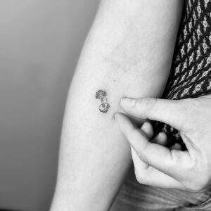 Micro tatuaje de pesas en el antebrazo