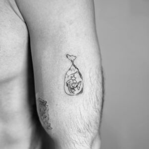 Tatuaje pequeño de una bolsa con pez en el brazo