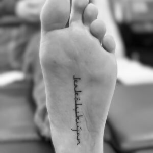 Tatuaje de palabra en la planta del pie