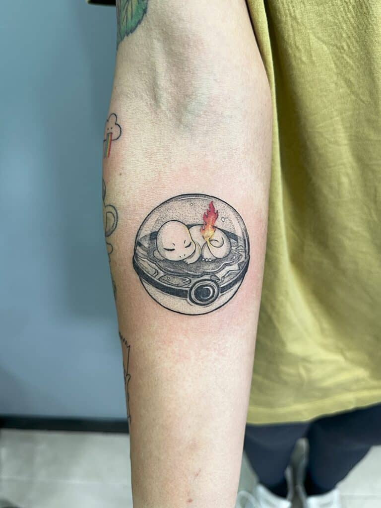 Tatuaje de personaje de serie de TV Pokemon en el antebrazo con toque de color