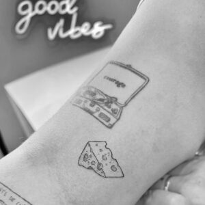 Tatuaje de línea fina de queso en el brazo