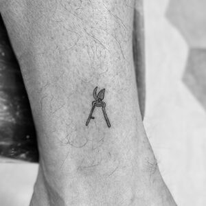 Micro tatuaje de tijeras en el tobillo