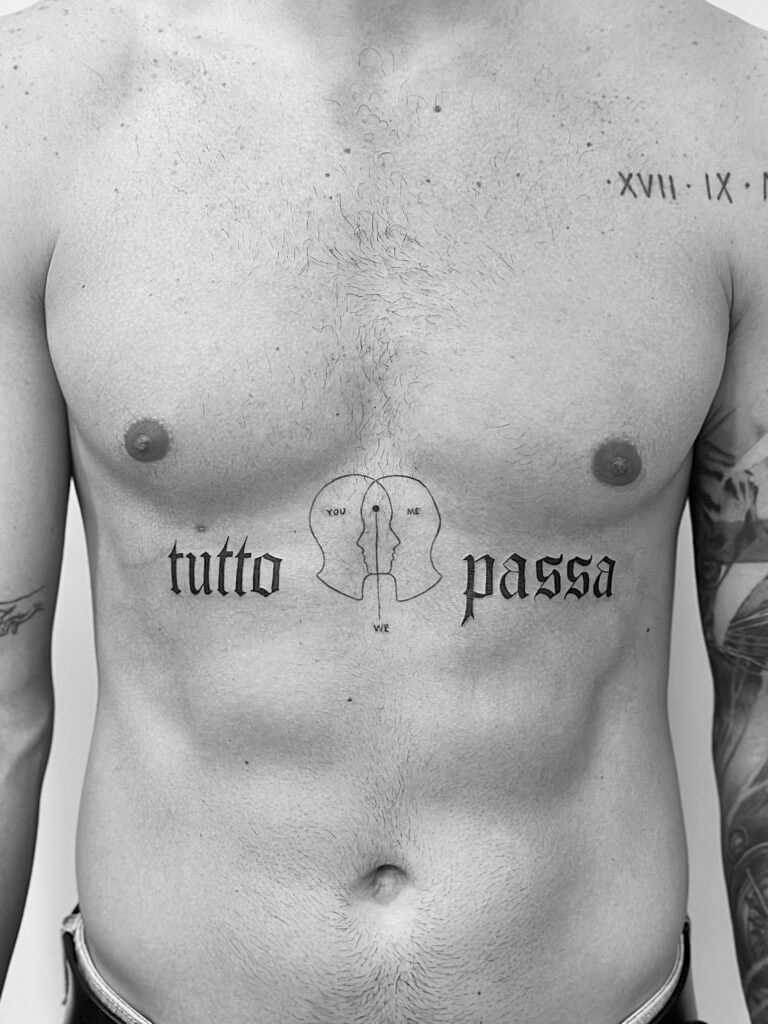 Tatuaje de frase grande en pecho con siluetas