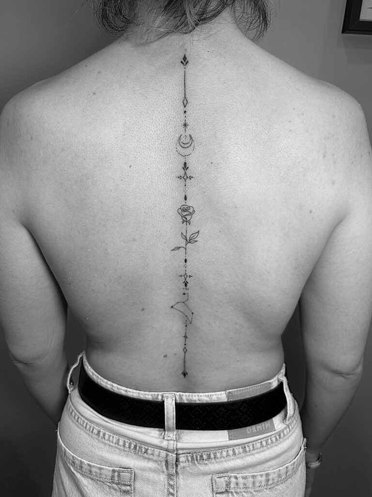 Tatuaje alargado con diferentes elementos que recorre toda la columna