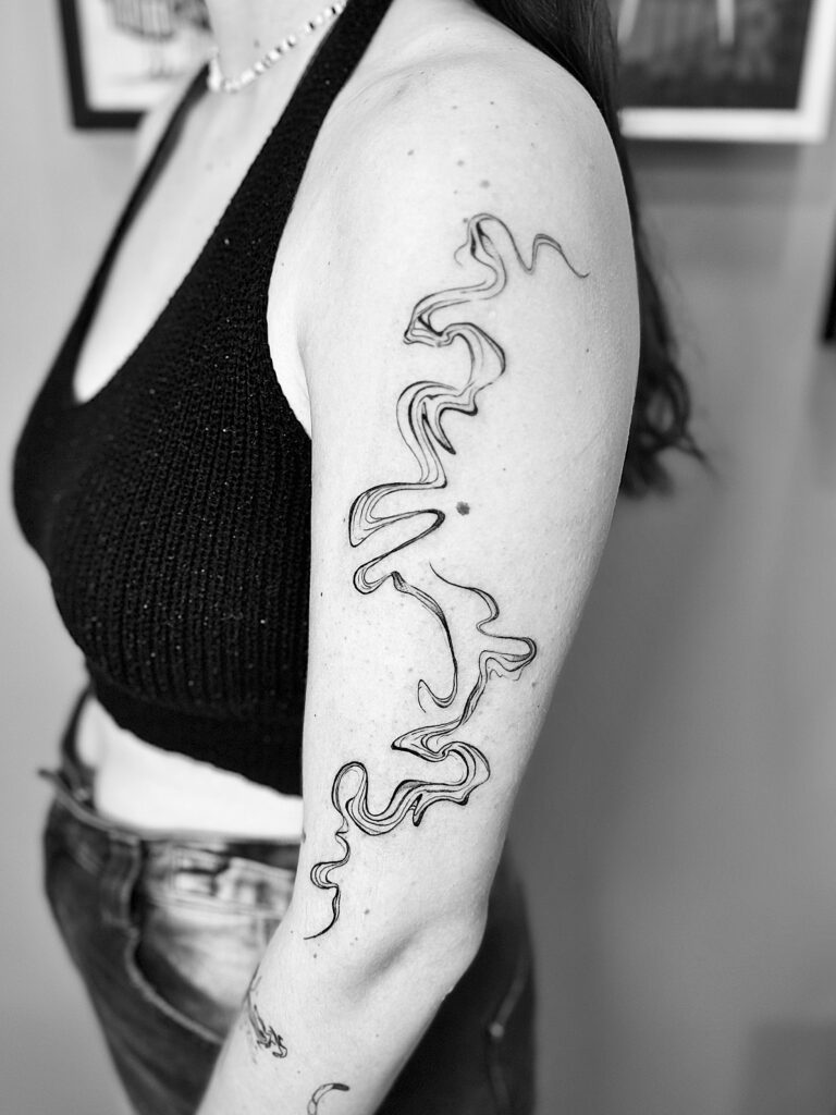 Tatuaje de líneas curvas abstractas recorriendo el brazo