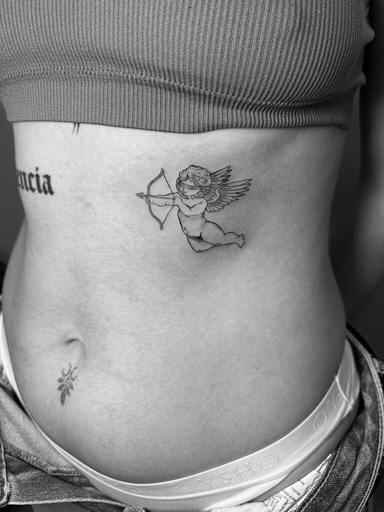 Tatuaje en línea fina de un cupido con los ojos vendados en las costillas