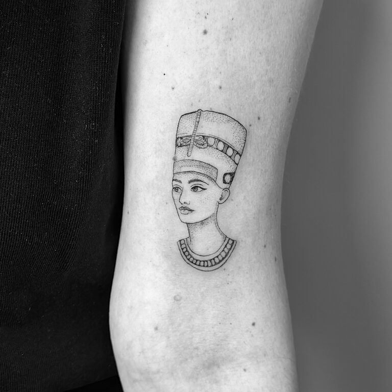 Tatuaje en línea fina de un busto de una mujer faraón en el brazo