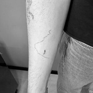 Tatuaje minimalista de corredor con camino