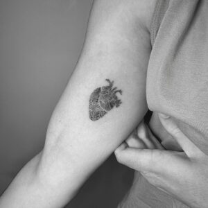 Tatuaje pequeño de corazón anatómico con huellas dentro