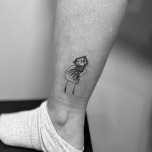 Tatuaje pequeño de un dibujo niño en pierna